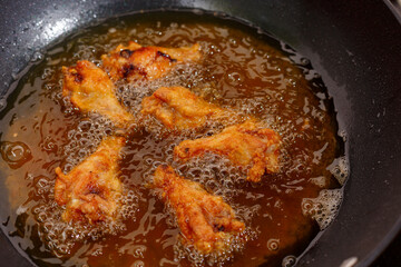 Close up fried chicken wings in boiling oil