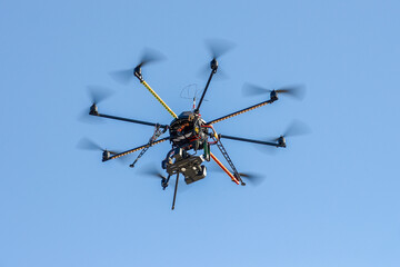 industrial drone with a video camera on a background of blue sky