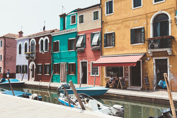 Panoramic view of coloured homes and water canal with boats in Burano