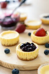 Mini cheesecake with blueberry, blackberry and strawberry ready to be served on wooden table