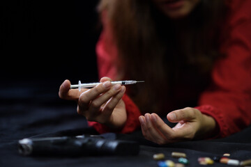 Drugs and hopeless concept. Drug addict woman with a syringe using drugs - obrazy, fototapety, plakaty