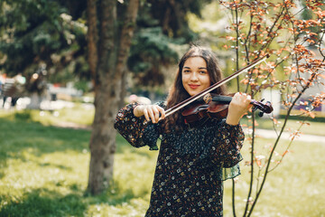 Girl in a summer park. Lady with a violin. Girl in a summer dress