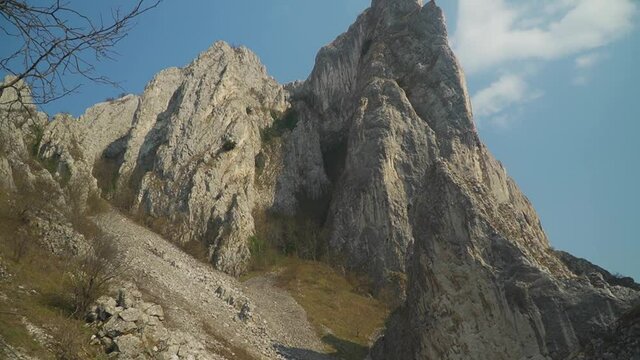 Climbers Hike Towards Steep Mountain - Via Ferrata - Tilt up wide shot