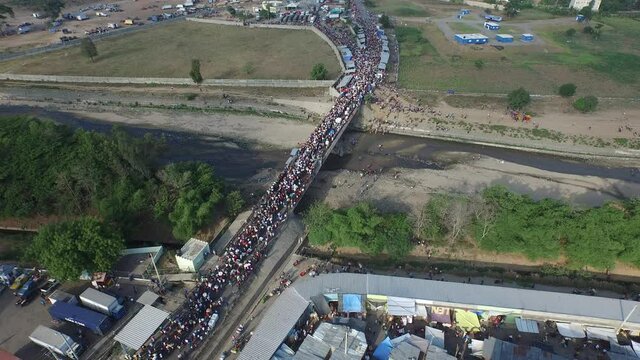 Aerial backward of Dajabon bridge and mass of people crossing border. Dominican Republic