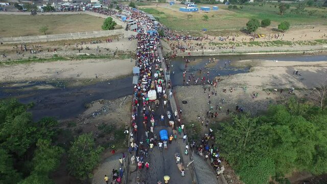 Aerial static shot of Haitians pass border on Dajabon bridge. Dominican Republic.