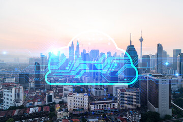 Glowing hologram of cloud icon, aerial panoramic cityscape of Kuala Lumpur at sunset. The concept of secure storage of digital data in KL, in Malaysia, Asia. Multi exposure.