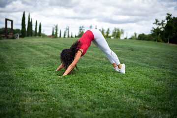 Fototapeta na wymiar Young pretty fitness woman doing yoga postures in a park on the grass with white clothes