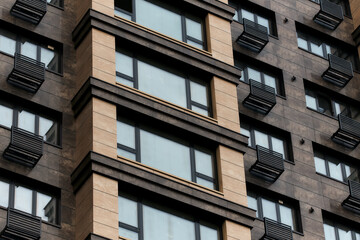 The facade of the building with windows and balconies, brown, without people. Stylish construction, cityscape. art