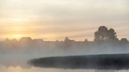 River before sunrise in the fog