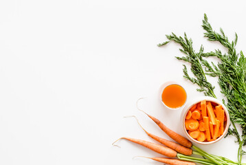 Obraz na płótnie Canvas Sliced carrot and juice on white table top view copy space