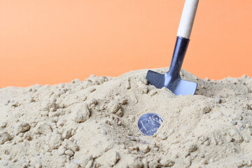 metal coin Russian ruble and a shovel in the sand
