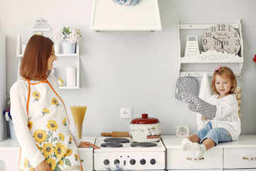 Cute little son with mother. Family at home in a kitchen.