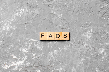 faqs word written on wood block. faqs text on table, concept