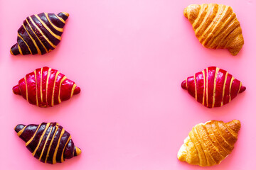 Set of croissants - chocolate, berry, classic - on pink desk top view