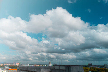 Aerial view of cityscape & modern city  with beautiful sunny blue sky with puffy fluffy white clouds & cotton candy cloudscape on background in tropical summer or spring morning sunlight & sun rays 