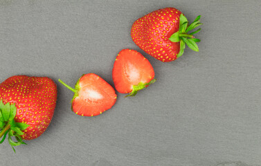 Fresh and sweet strawberries laid out on a table on a dark background