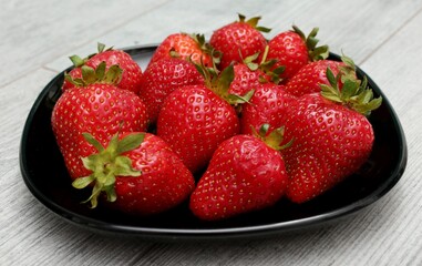 strawberries in a bowl on wooden table