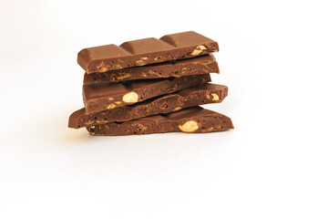 Chocolate slices are stacked on a white background.Dark chocolate with nuts.