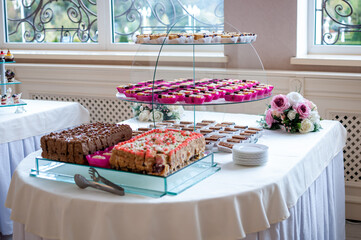 Sweet cakes at a wedding buffet. Catering