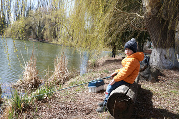 Boy fishing on lake in spring