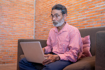 Old man learning to use a laptop at home,Senior man use computer work from home social distancing stay home stay safe.