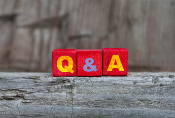 Q&A word on a cube blocks, close up, question and answer concept.