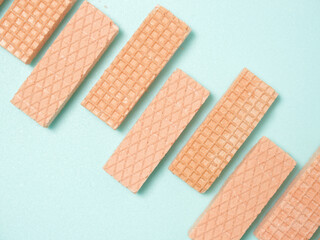 Pink Wafer biscuits in a pattern and shape on a blue background with space for copy