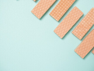 Pink Wafer biscuits in a pattern and shape on a blue background with space for copy