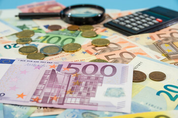 Euro banknote, calculator and magnifier. Much money. Savings concept. Financial concept. 500 euros on a background of euro banknotes.