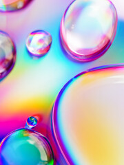Abstract composition. Drops of liquid are on an iridescent surface. Slightly defocused image. Trending background of saturated colors and gradients.