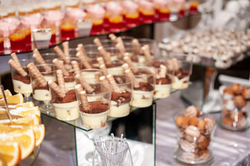 Sweet cakes in cups at a wedding buffet. Candy bar catering