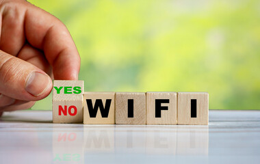 The hand turns the wooden cube and changes the word NO WIFI to YES WIFI