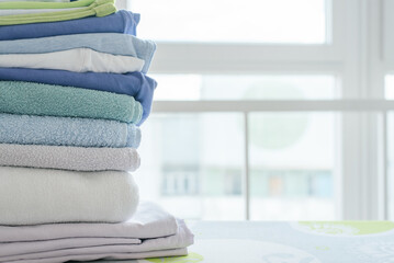 Stack of clean clothes on ironing board close up.
