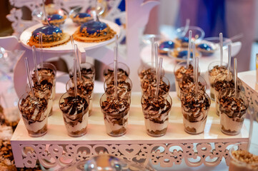 Sweet cakes in cups at a wedding buffet. Candy bar catering