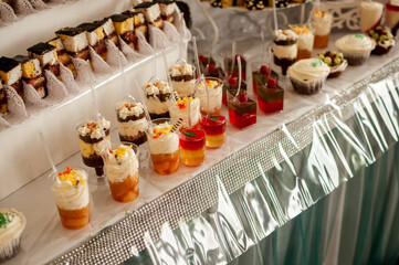 Sweet cakes in cups at a wedding buffet. Candy bar catering