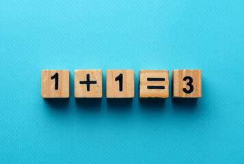 wooden cubes with the numbers 2 and 1 on a blue background. take two third goods as a gift. three for the price of two