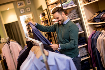 Handsome young man buying clothes in fashion store