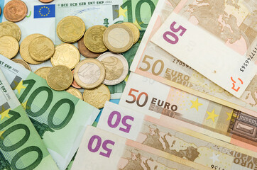 100 and 50 euro banknotes and coins. Financial concept. Much money.