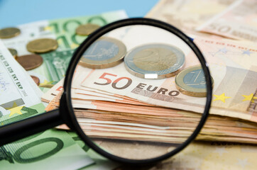 50 euros through a magnifier. Close-up. Financial concept. Much money. Stack of Euros and coins.