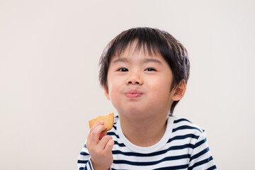 Little boy eat cookie on white background
