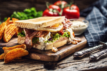 Bacon and sunny side up egg grilled toast with spicy potato wedges and sauce on the side