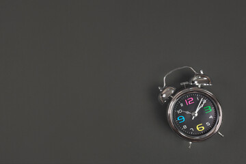 Metal antique alarm clock on black background with space for text. Back to school concept. Flat lay, Top view.