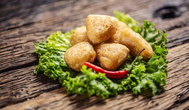 Spicy cheese nuggets with fresh chilli placed on leaf of salad
