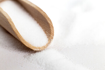 Salt grain in wooden spoon top view on a white background , flat lay.