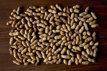 Peanuts on wooden table. Seen from above peanuts still in their shell.