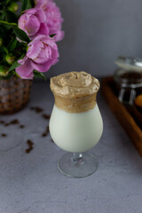 Milk shake. Dalgona coffee - the Korean coffee drink on wooden background. Instant coffee or espresso powder whipped with sugar and hot water. Iced whipped dalgona coffee concept.