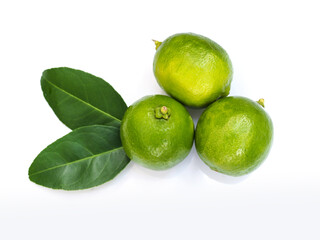 Fresh green lemons with leaves isolated on white background