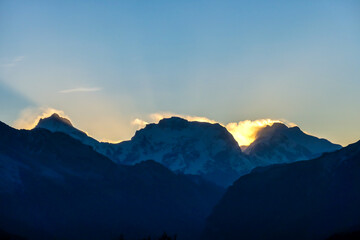 A soft and early sunset in the nearby of Thorung La Pass, Annapurna Circuit Trek, Nepal. Harsh and barren landscape around. Clear and blue sky. High Himalayan ranges in the back. Snow capped mountains