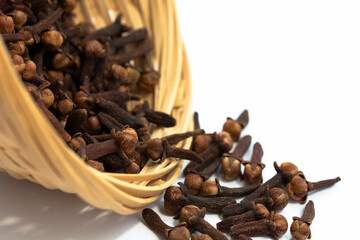 dried cloves in a basket and clear cloves on a white background.