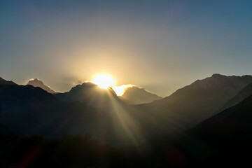 A soft and early sunset in the nearby of Thorung La Pass, Annapurna Circuit Trek, Nepal. Harsh and barren landscape around. Clear and blue sky. High Himalayan ranges in the back. Snow capped mountains